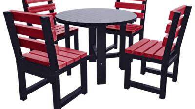 Black round garden table with four red chairs made from recycled plastic.