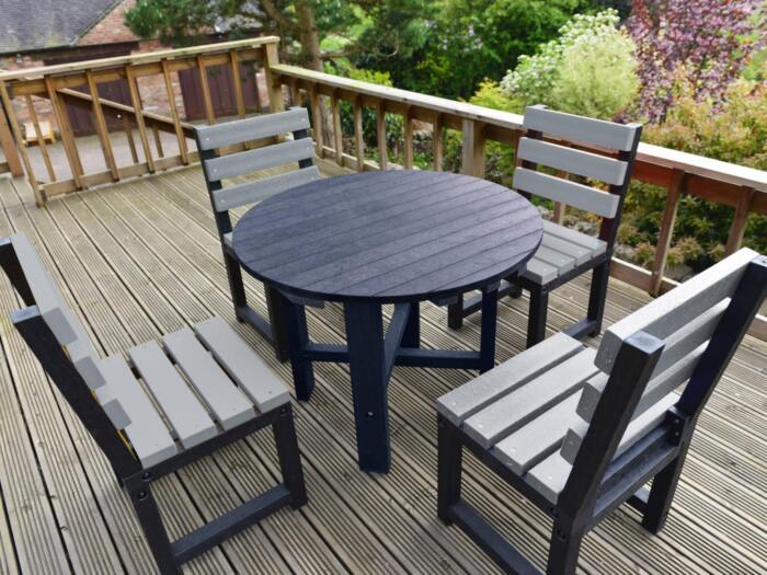 Featherstone Round set 4 - Black Table - Grey Chairs Black round garden table with matching black chairs made from recycled plastic.