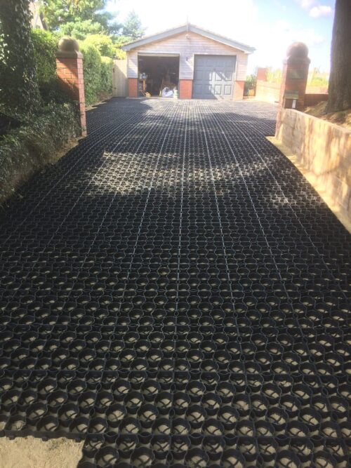 Residential driveway featuring our everyday permeable ground reinforcement grids, leading to a twin garage at the end.