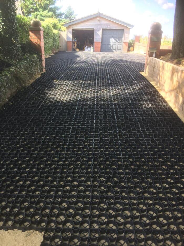 Hebden Everyday Grid driveway Residential driveway featuring our everyday permeable ground reinforcement grids, leading to a twin garage at the end.