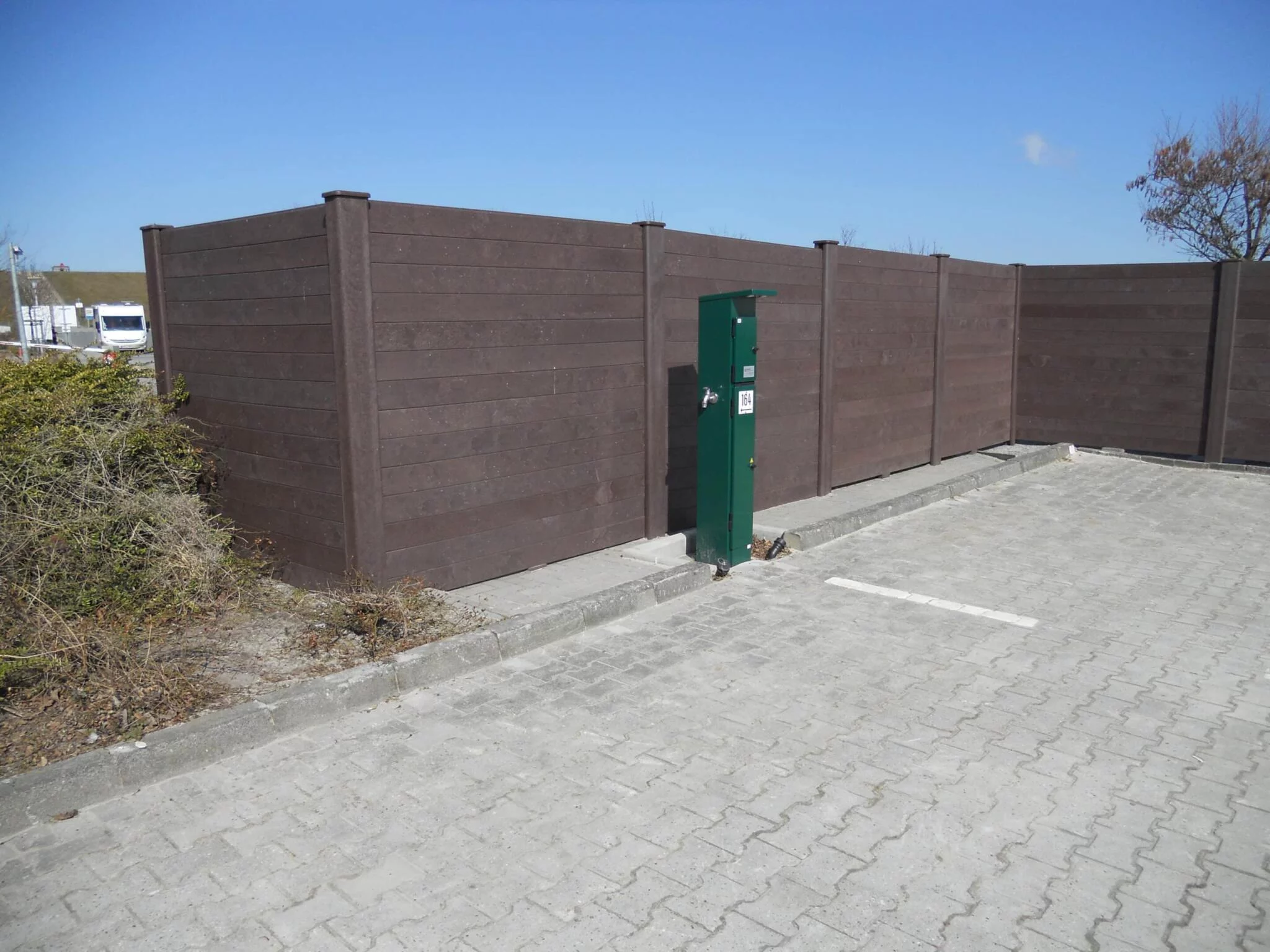 a fence with a green box with Everson Museum of Art in the background using plastic wood