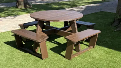 Brown picnic table on green grass. Calder Picnic Table British Recycled Plastic