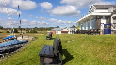 1 black artificial lumber British Recycled plastic bench next to a boat club