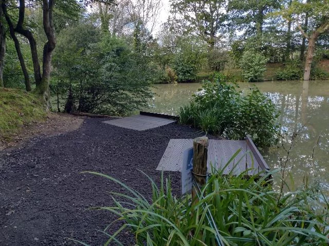 Two fishing platforms on a small lake surrounded by lush green foliage.
