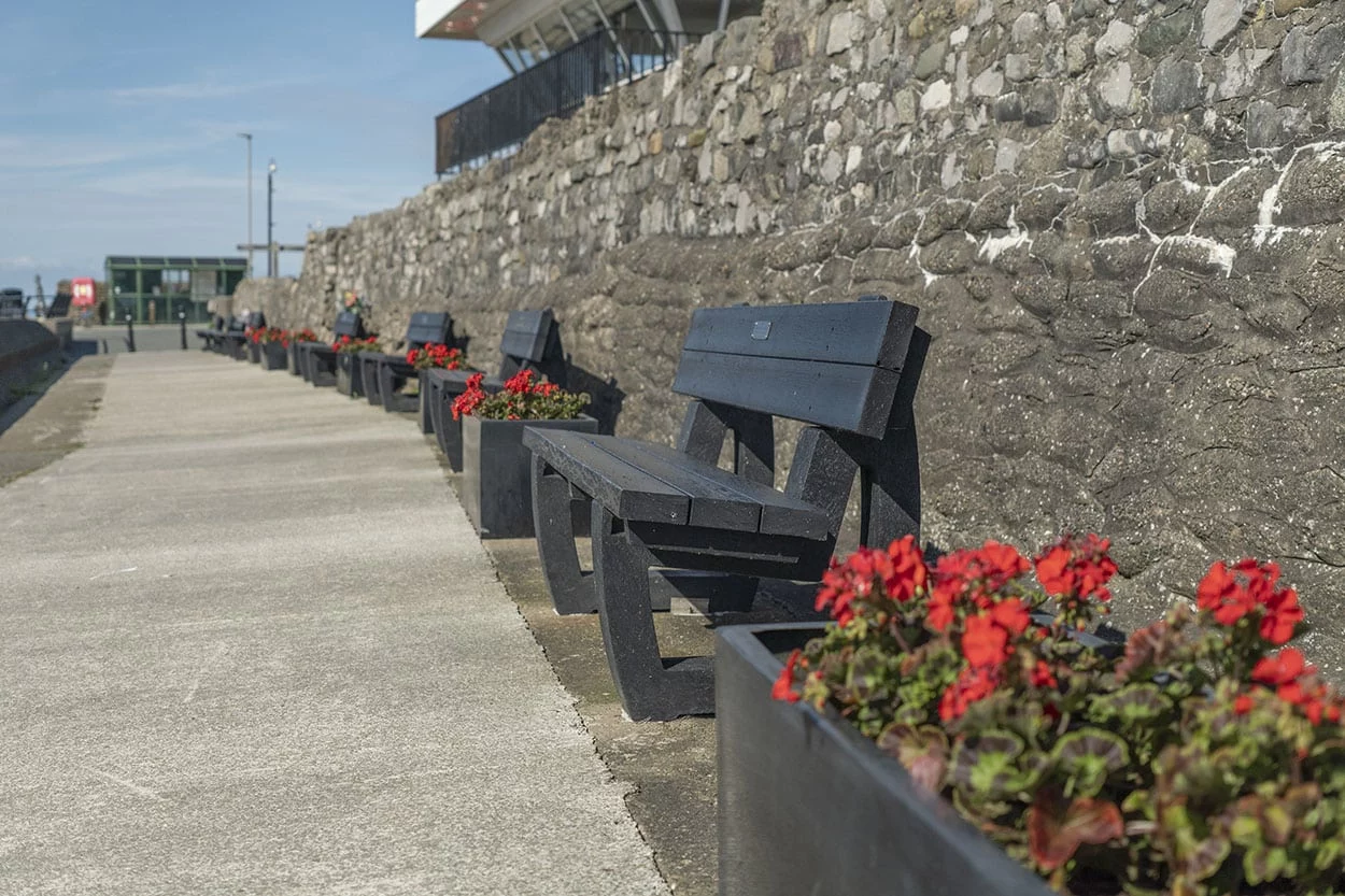 Preesall Town Council Ferry Cafe seafront self-build planters + Harewoods Greay British recycled plastic benches next to greay planters with red flowers