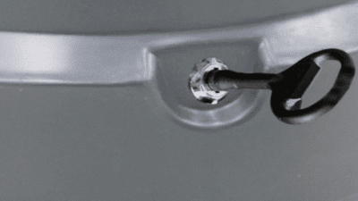 Black key unlocking the lid of a recycled plastic litter bin