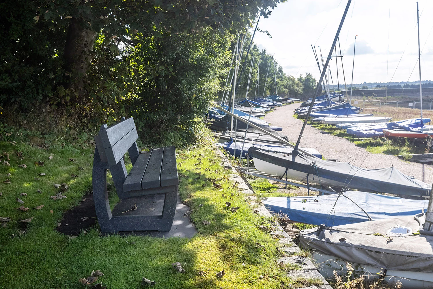 a picture of a grey recycled plastic benches overlooking sailing boats at a boat club