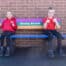 2 children smiling adn with thumbs up sitting on a british recycled plastic buddy bench