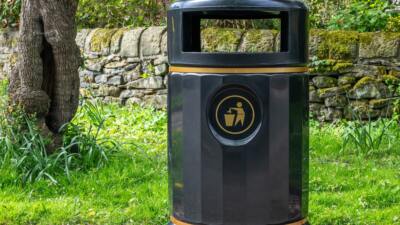 black and gold recycle plastic bin on the street