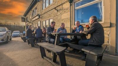 Men enjoying drinks outside a pub on a British Recyled Plastic Calder picnic table