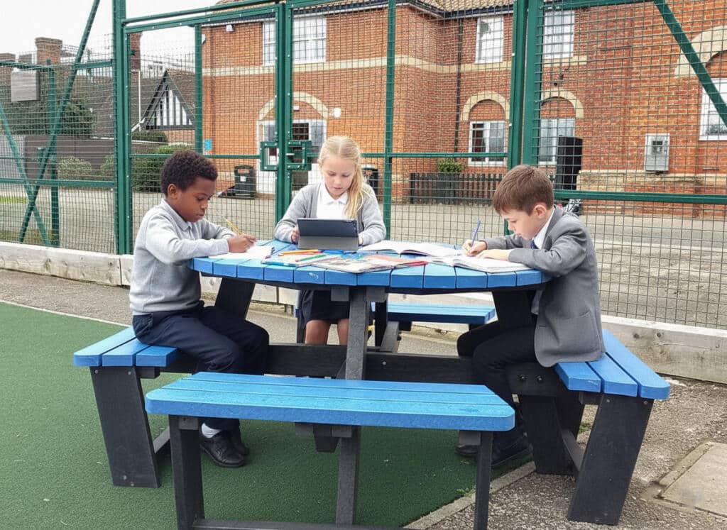 Children studying at a playground table British on a Recyled Plastic Calder picnic table