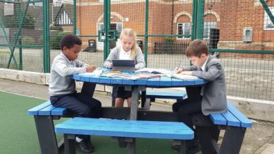 Children studying at a playground table British on a Recyled Plastic Calder picnic table