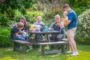 a family laughing near a British Recycled Plastic picnic table
