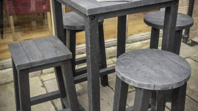 Grassington Poser table with stools in black in sitiu Poseur table and 4 stools from British recycled plastic - grey with 4 legs. 4 Round and Square stools/ Located at a hospitality venue