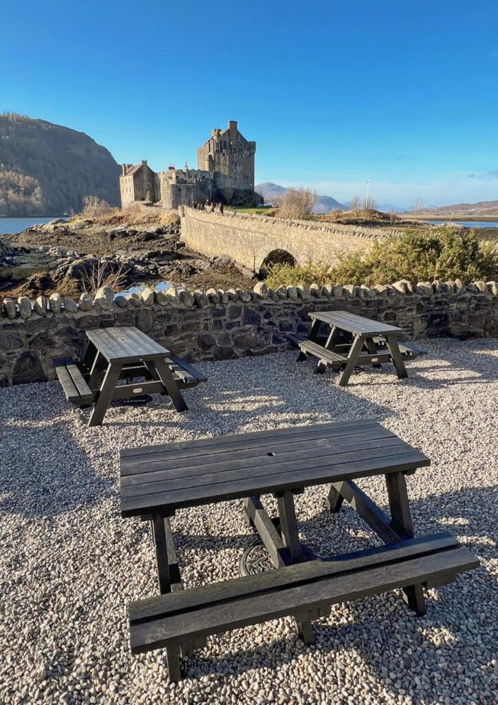 picnic tables in front of a castle and bridge