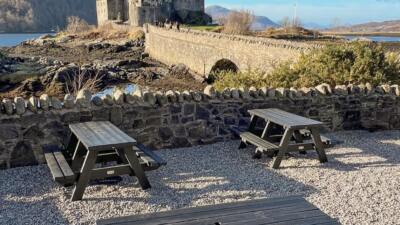 picnic tables in front of a castle and bridge