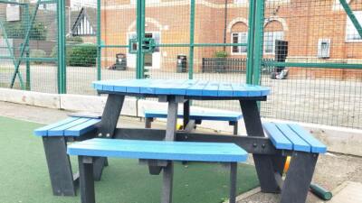 Blue recycled plastic picnis table in sunny play area