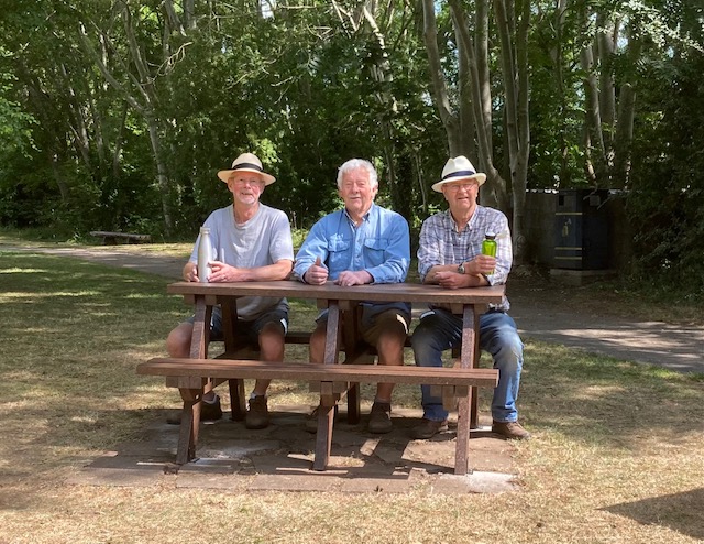 Recycled Plastic vs Composite Picnic Tables: Which Material Is Better? 4 3 men sat smiling on a brown picnic table with woodland in the background