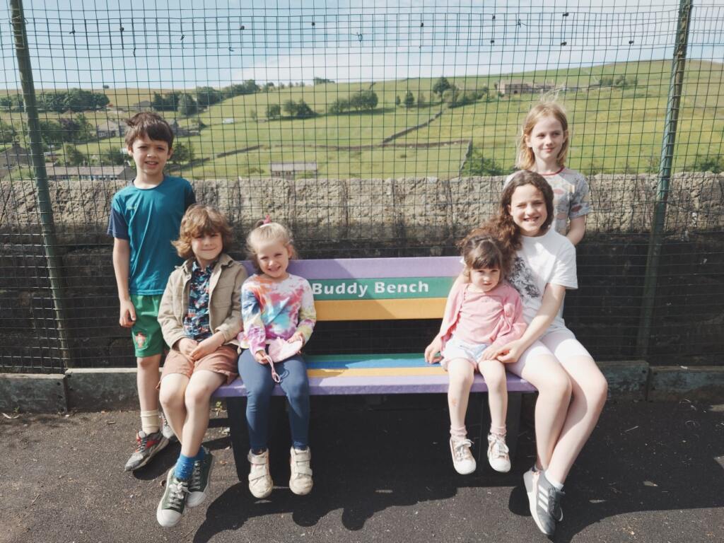 Kids enjoying a buddy bench and a local sports club