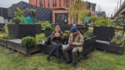 People taking a lunch break in the pleasant surroundings of recycled plastic parklets in Nottingham
