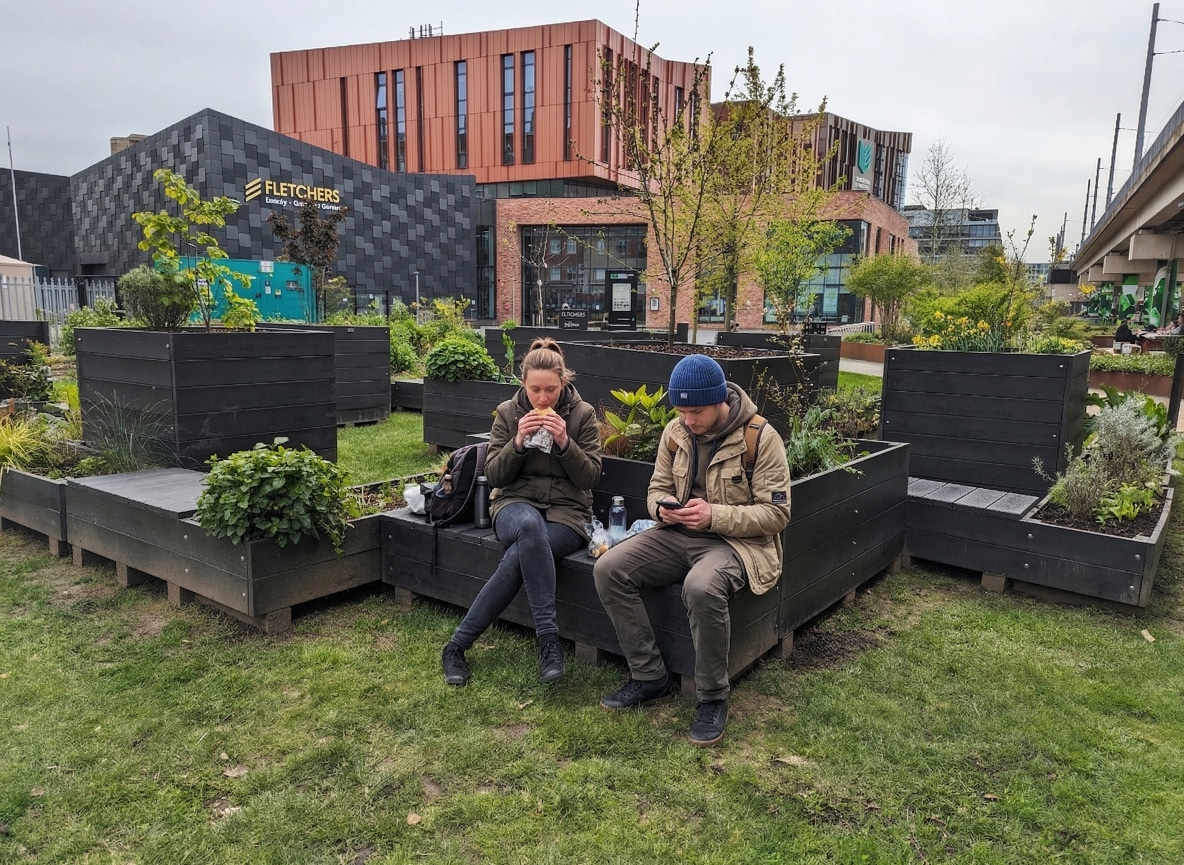 People taking a lunch break in the pleasant surroundings of recycled plastic parklets in Nottingham
