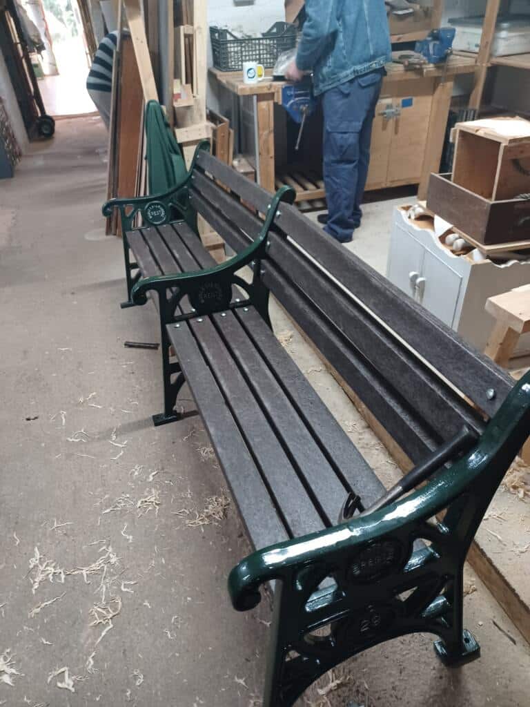 A recycled plastic memorial bench restoration in progress.