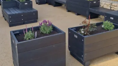 rectangular recycled plastic parklet with flowers in a community space