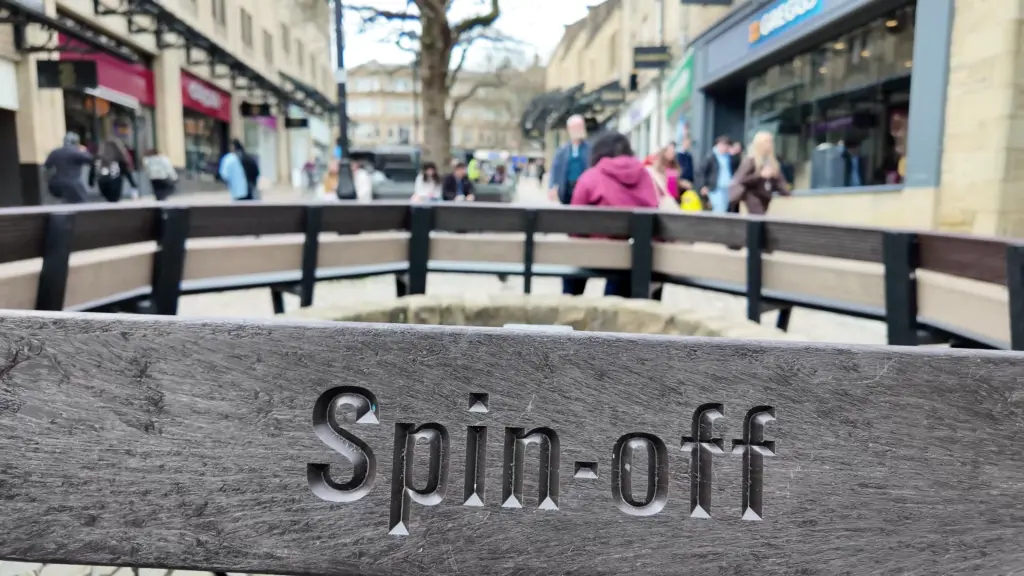 A close-up of one of the Calverley bench sections. The recycled plastic tree bench slats have been engraved with various phrases to celebrate Halifax's rich textile history.